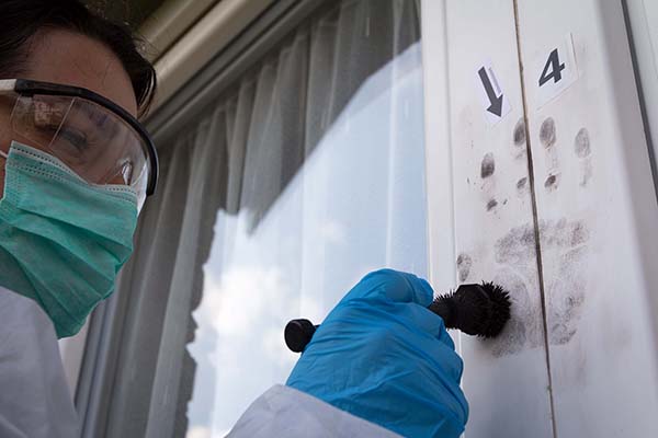 forensic science investigator dusting for latent fingerprints 