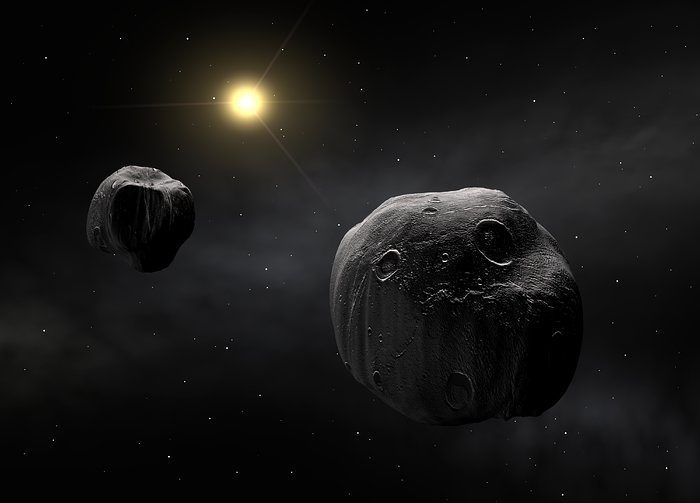 Double asteroid in foreground, shown as gray, cratered rocks, with a yellow star in the background