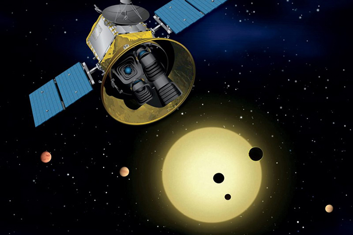 TESS satellite with transiting exoplanets crossing a star in the background, artist's impression.