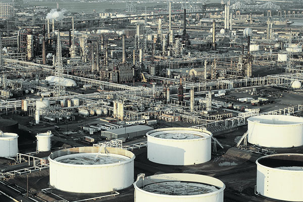 oil refinery and storage tanks within a sprawling cityscape