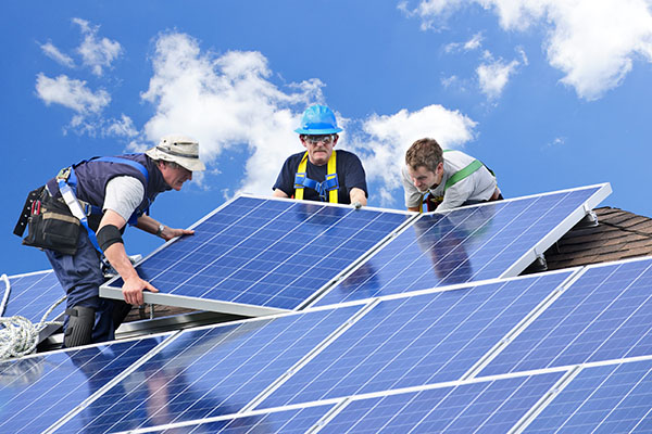 workers installing PV panels on a roof