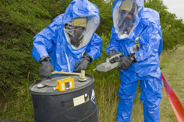 Photo of two people testing a drum contain unknown chemicals