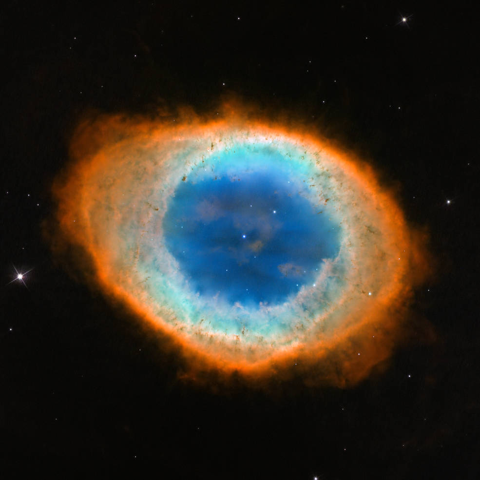 The Ring Nebula, which id oval-shaped and in optical light has a blue core surrounded by light yellow and orange shells, with a bright white dwarf at its center 